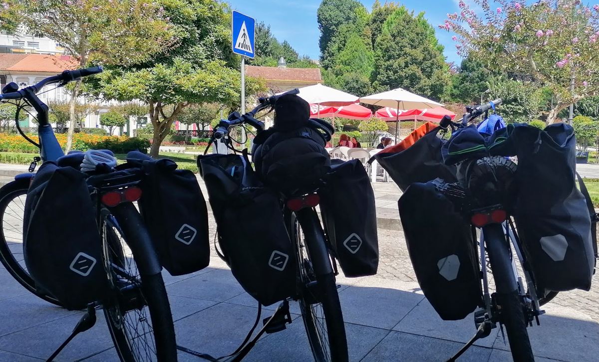 Três bicicletas carregadas com alforges, paradas numa praça
