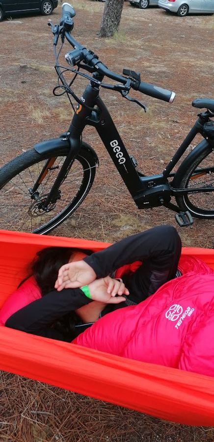 Uma das filhas a dormir numa rede, ao lado da bicicleta