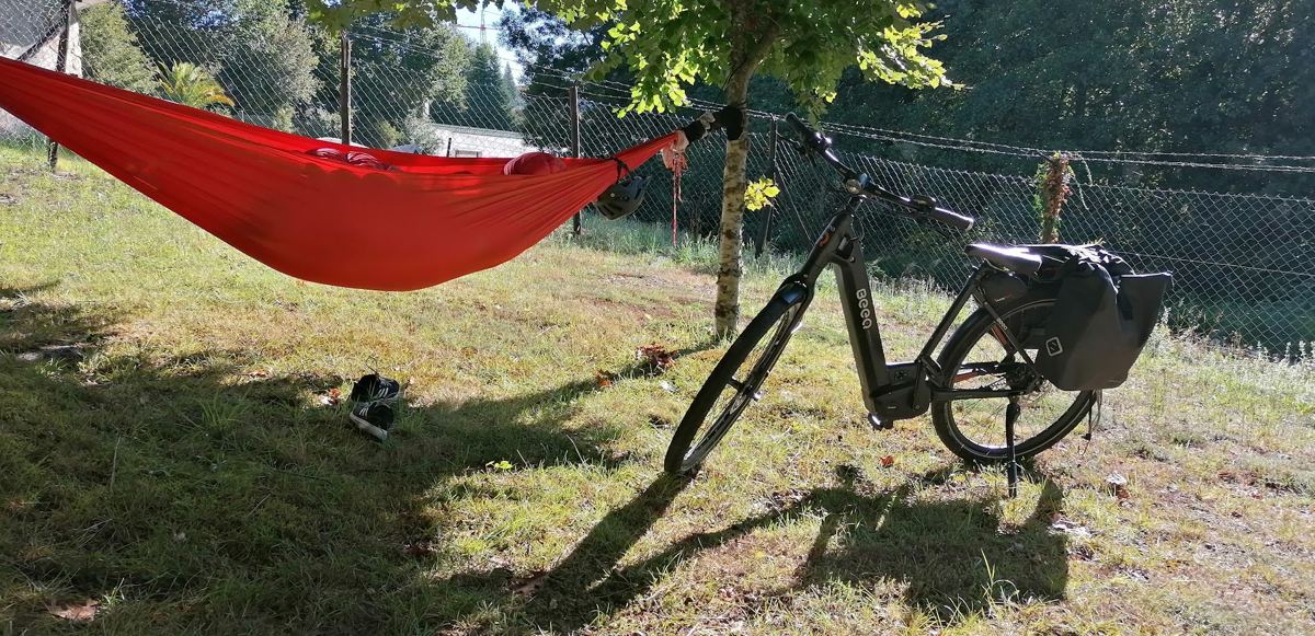 Rede vermelha e bicicleta ao sol, num relvado