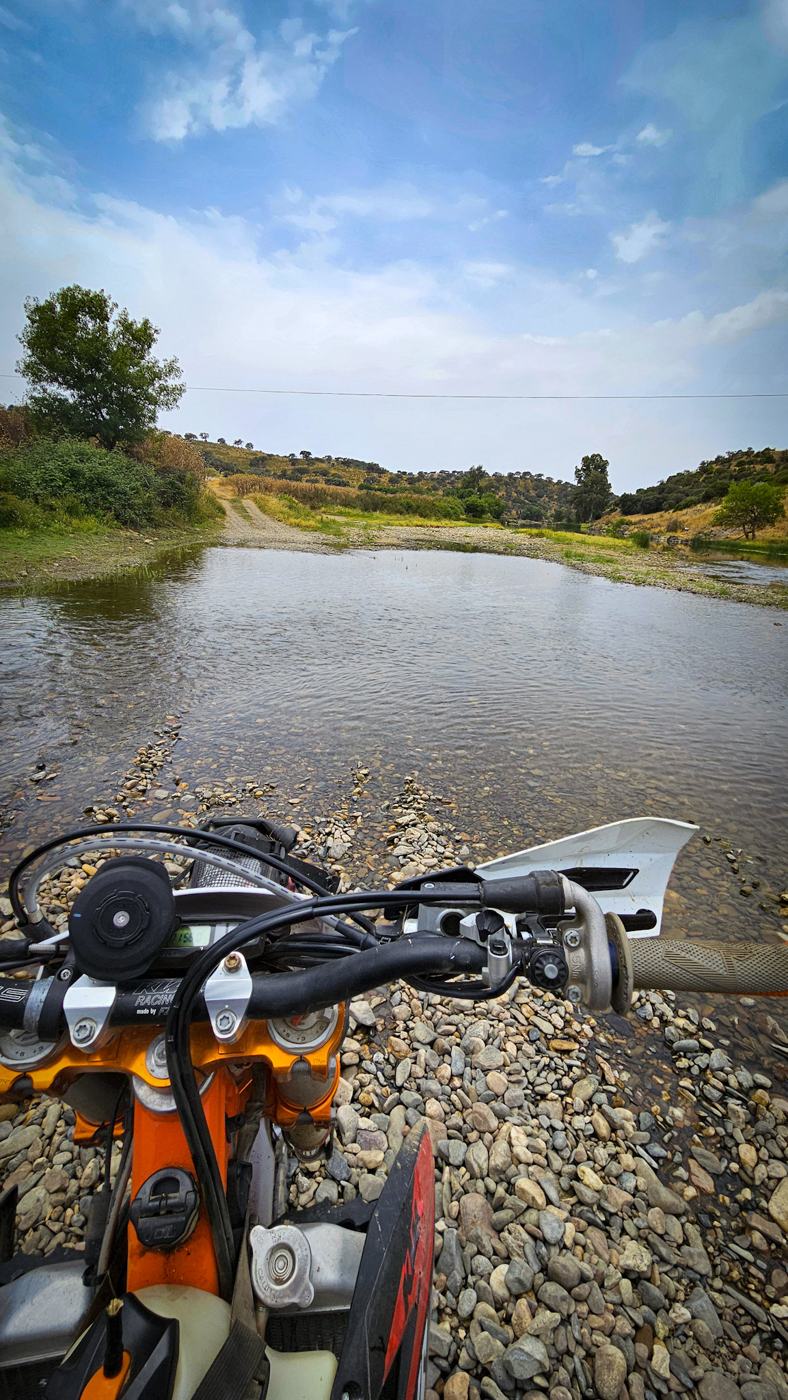 Moto de enduro parada junto a um rio no Alentejo